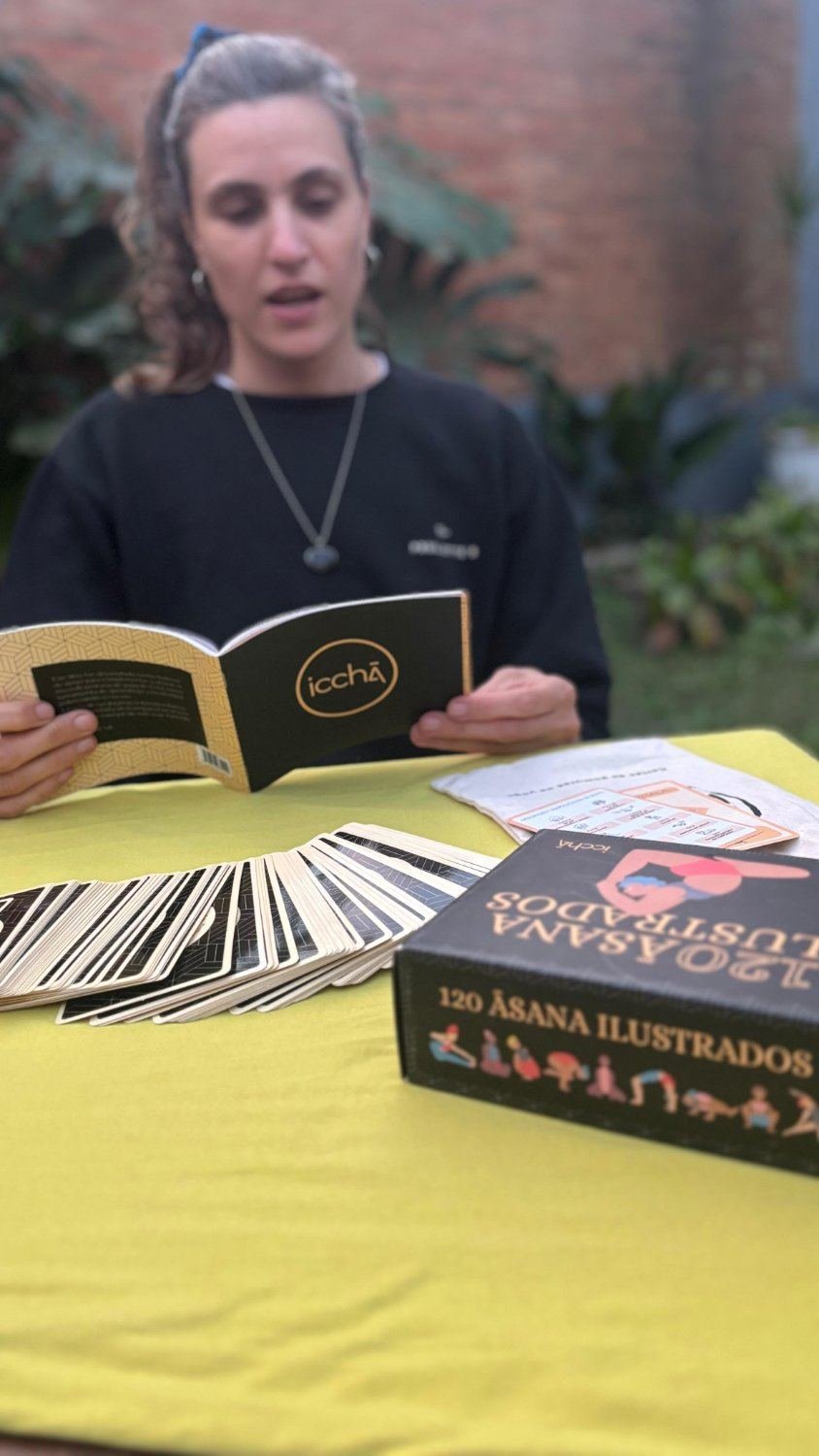 Practicante leyendo el libro pedagógico de ICCHĀ con el mazo extendido y la caja sobre la mesa